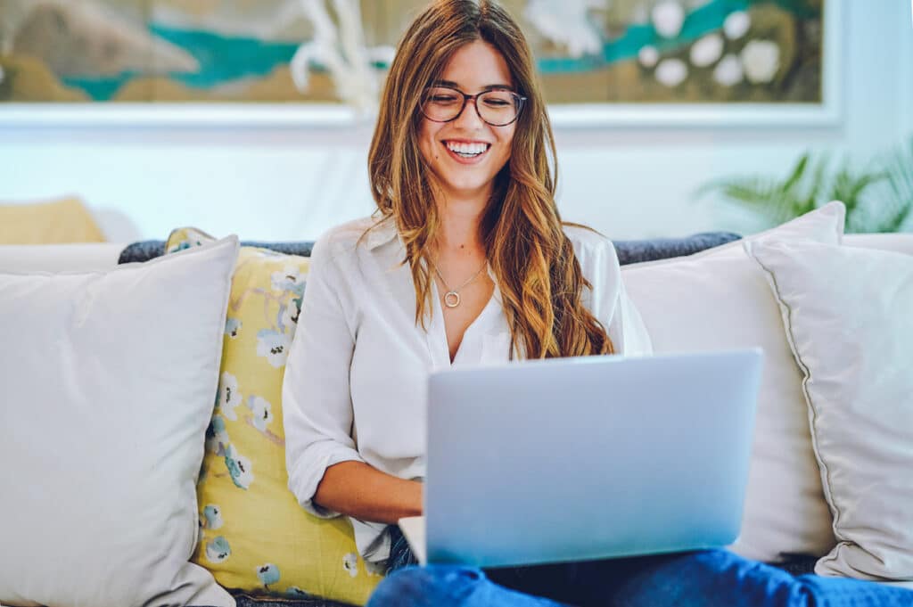 Shot of a young woman using a laptop on the sofa at home