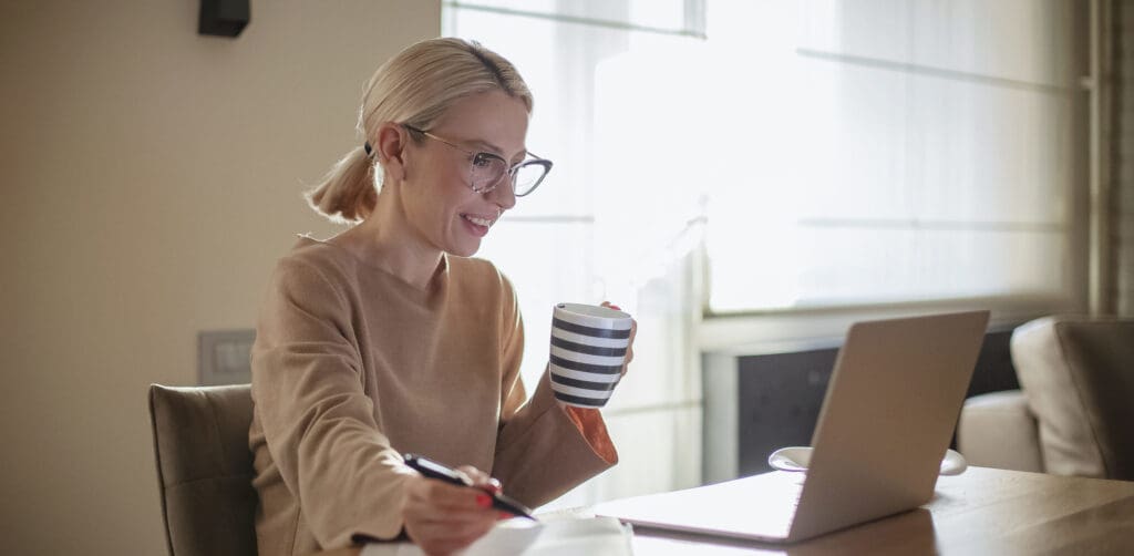 Woman working at home while having breakfast
