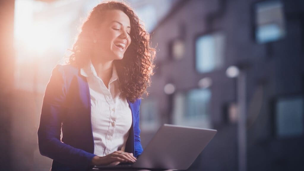Woman excitedly reading email on her laptop